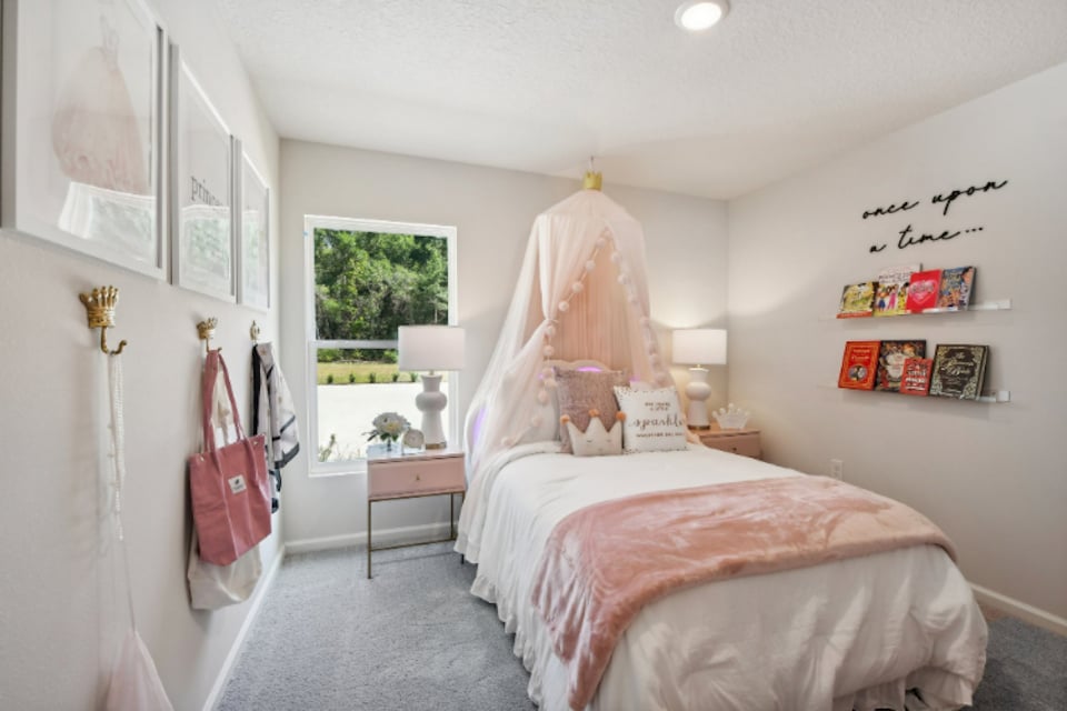 A bedroom with a pink bed.