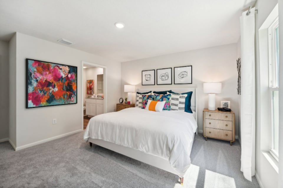 A bedroom with a bed and a lamp.