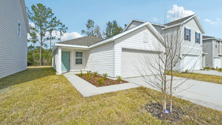 A white house with a tree in the front.