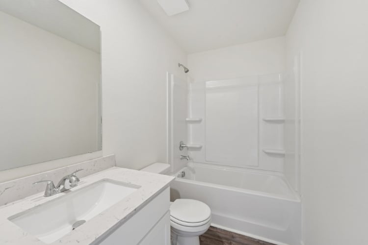 A bathroom with a tub sink and toilet.