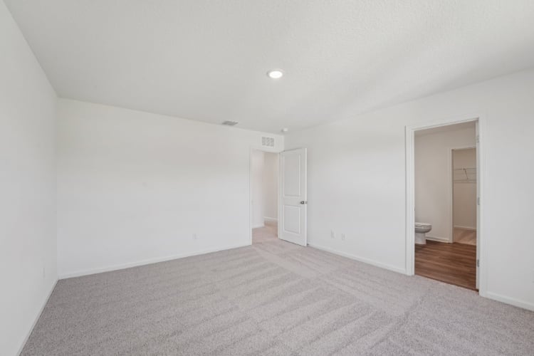 A room with a carpet and a door.