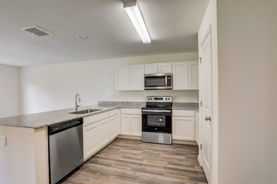 A kitchen with white cabinets.