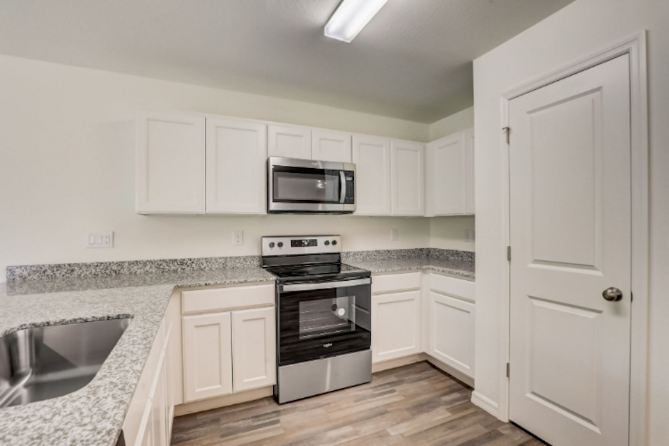 A kitchen with white cabinets.