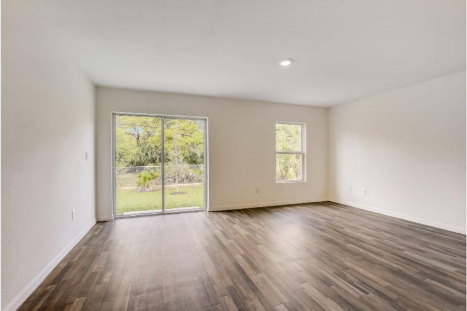A room with a wood floor and windows.