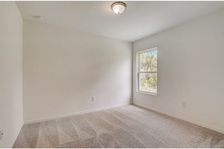 A room with a window and carpet.