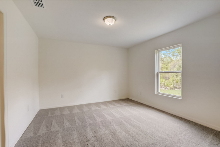 A room with a window and carpet.