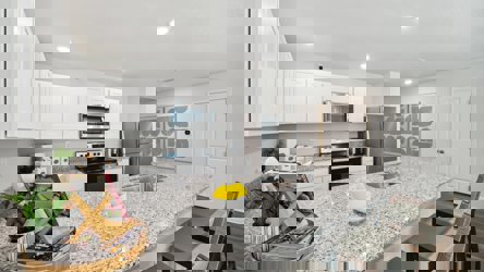 A kitchen with white cabinets.