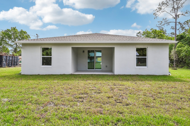 A white house with a grass yard.