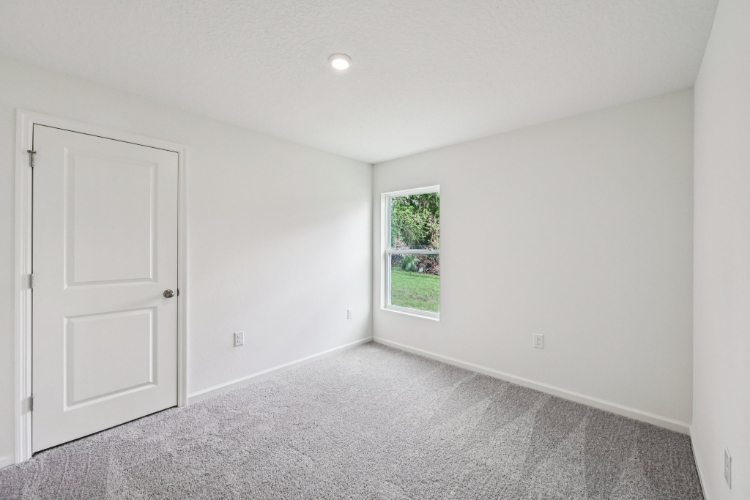 A room with white walls and a window.