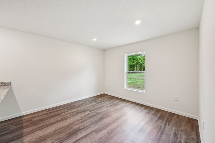 A room with a wood floor and a window.