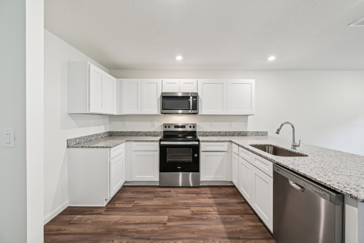 A kitchen with white cabinets.