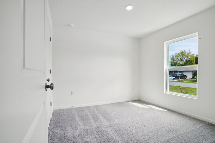 A room with a carpet and a window.