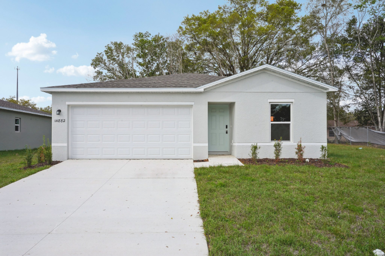 A white garage with a green lawn.