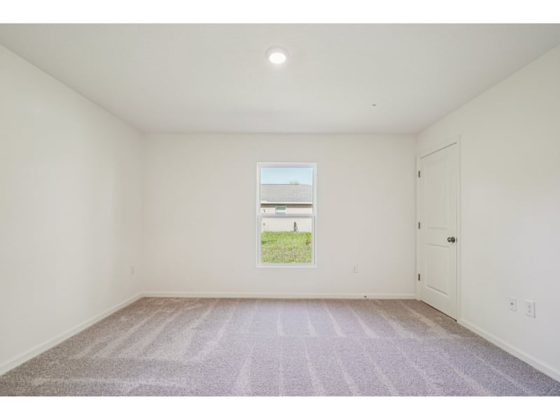 A room with a window and a carpet.