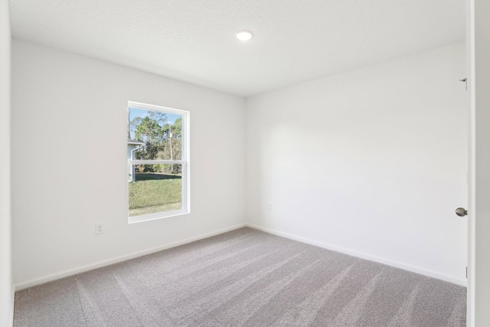 A room with a window and a carpet.