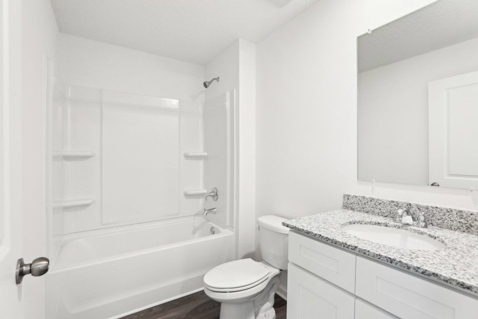 A bathroom with a tub sink and toilet.