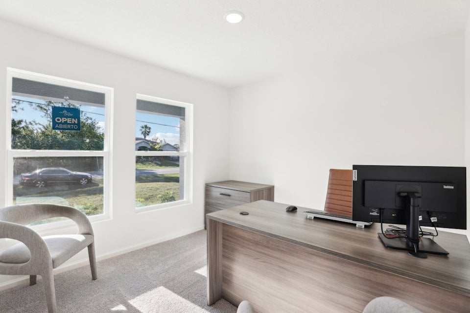 A room with a desk and a tv.