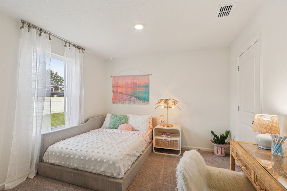 A bedroom with a bed and a window.