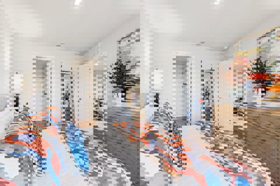 A bedroom with a bed and a dresser.