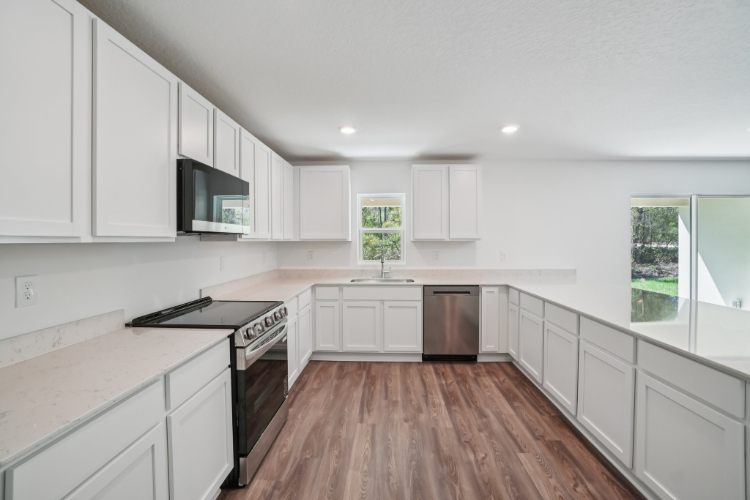 A kitchen with white cabinets.