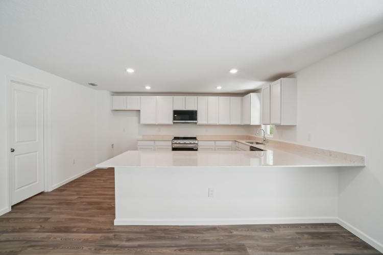 A kitchen with white cabinets.