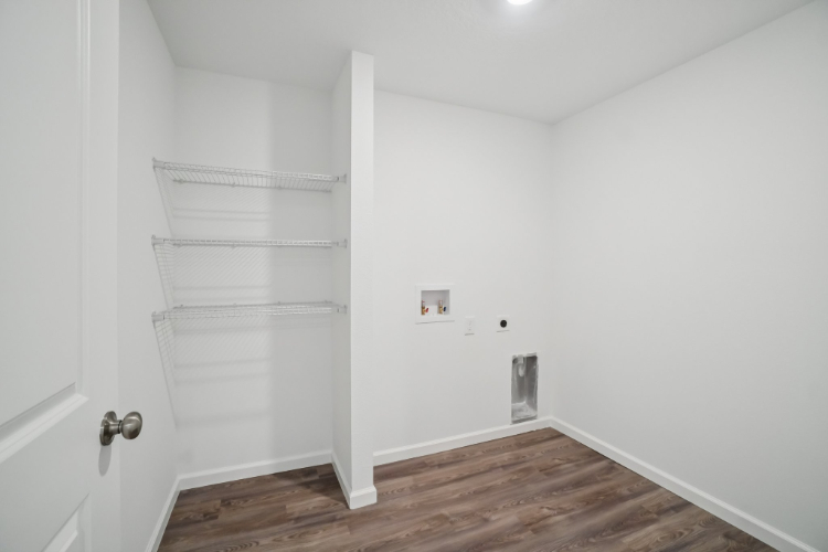 A white room with a wood floor and white walls.