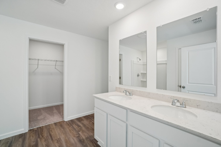 A bathroom with white cabinets.