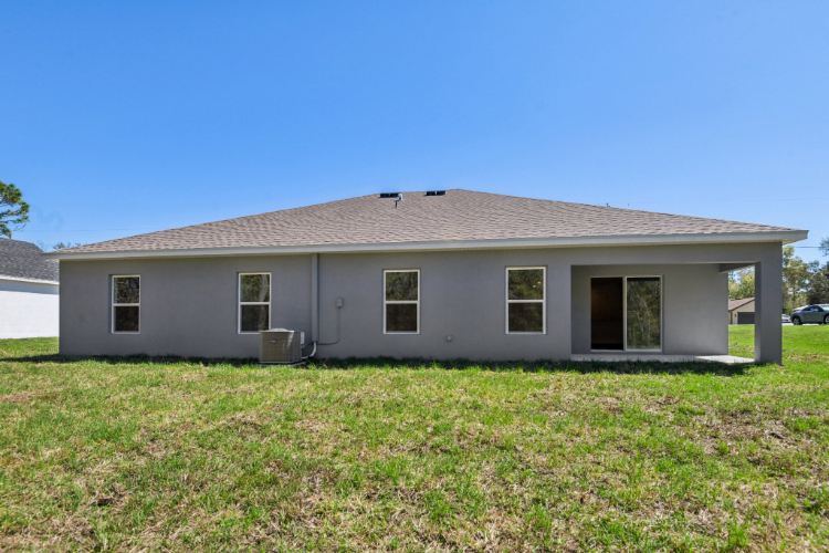 A white house with a grass yard.