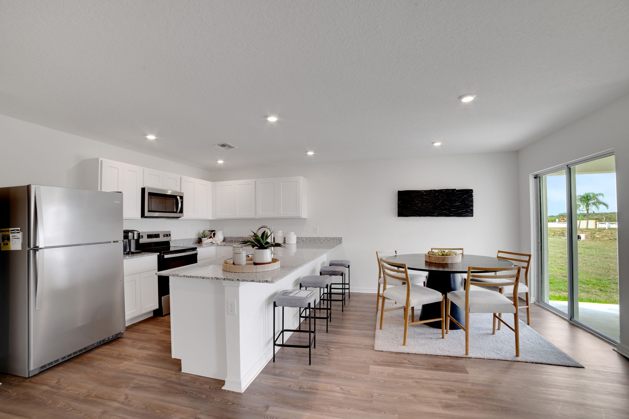A kitchen with a dining table and a large window.