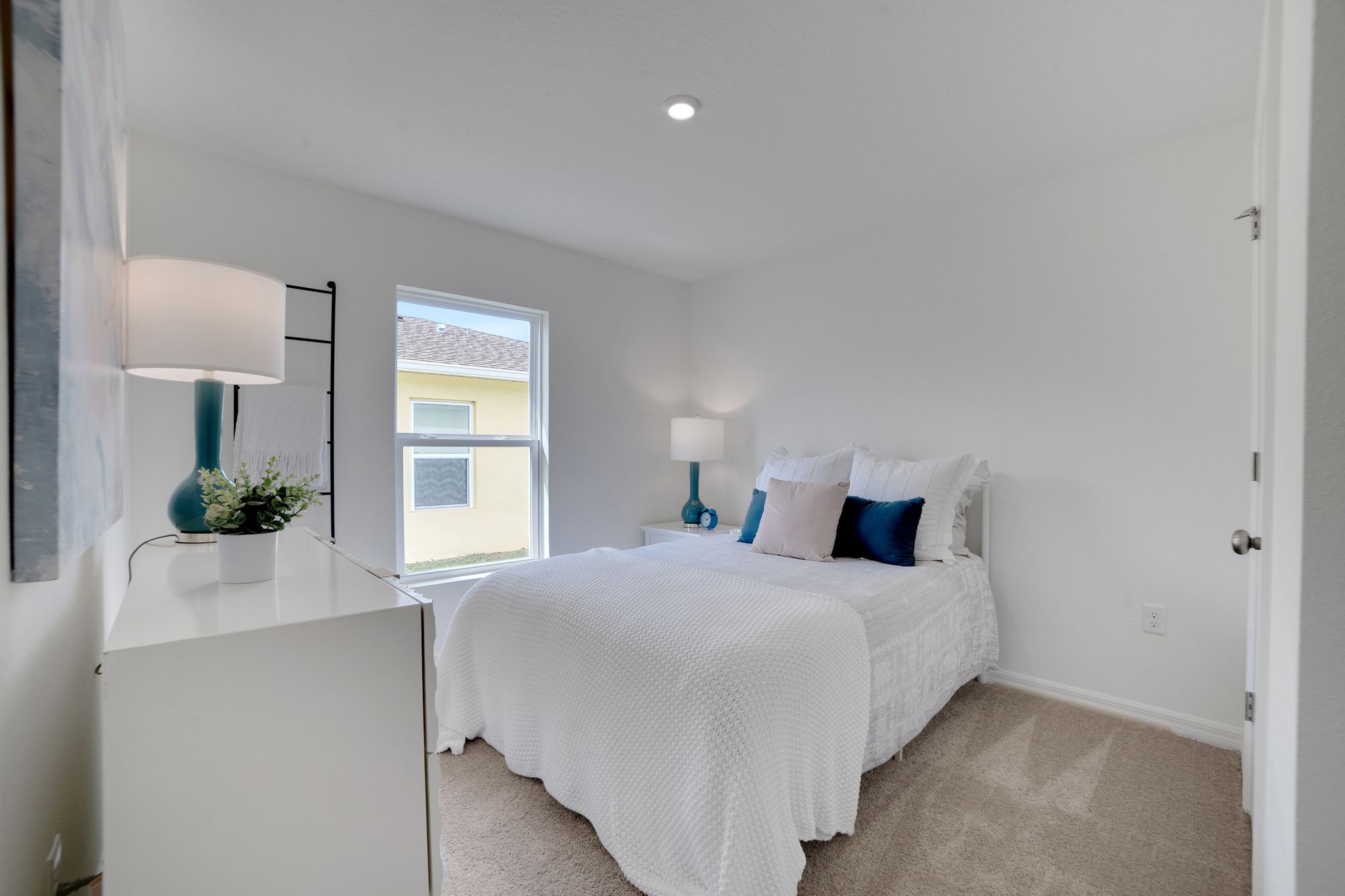 A bedroom with a bed and a lamp.