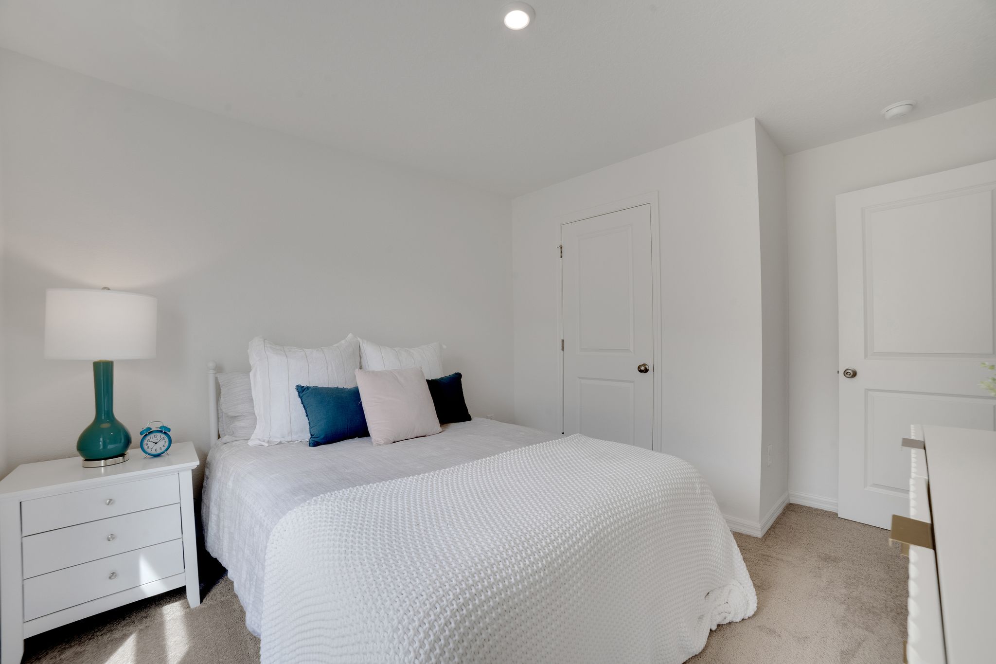 A bedroom with white walls.
