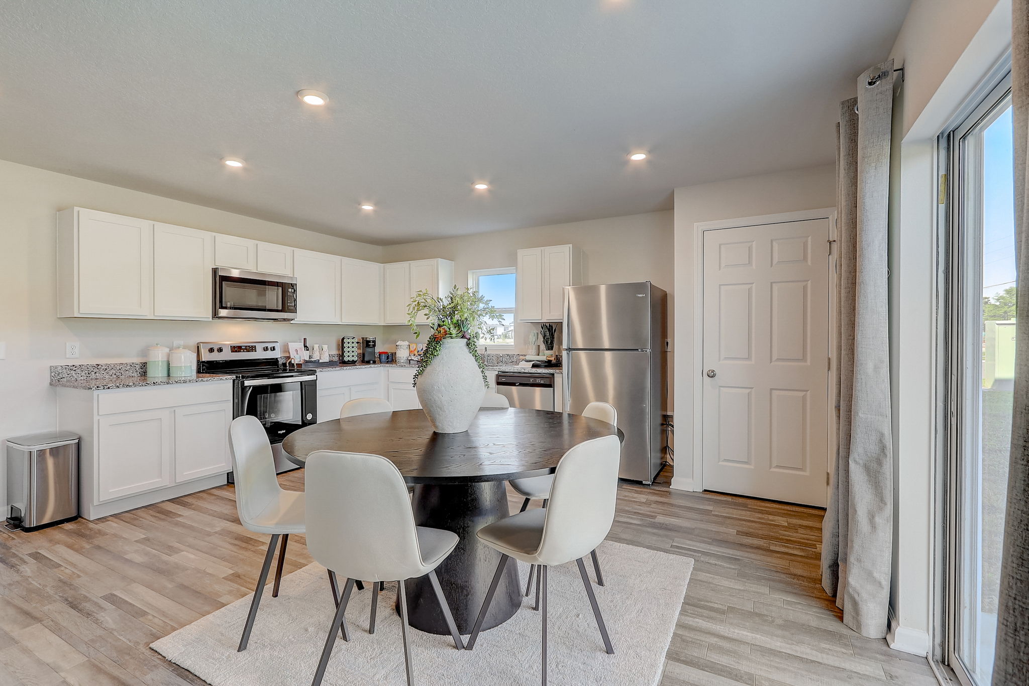 A kitchen with a dining table and chairs.