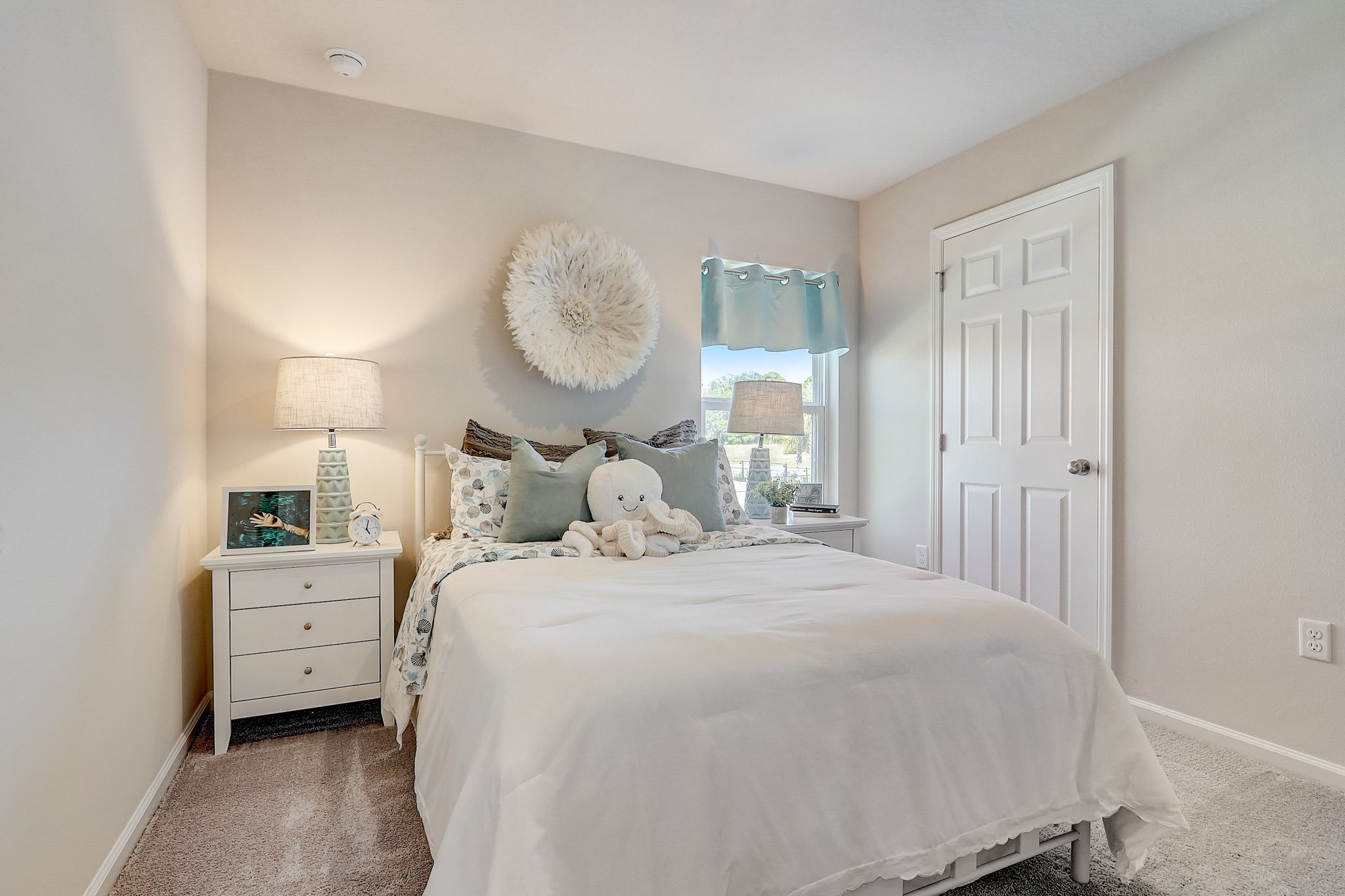 A bedroom with a bed and a lamp.