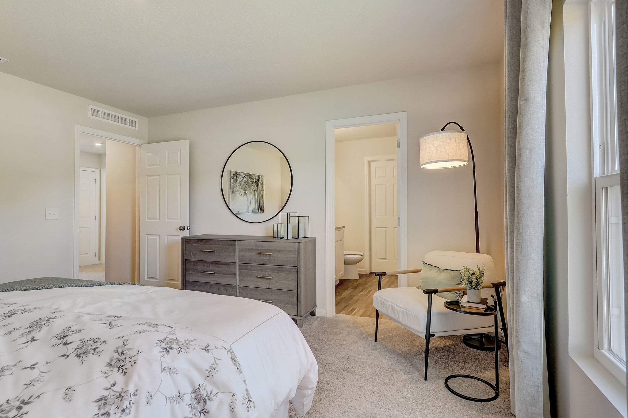 A bedroom with a bed and a table.