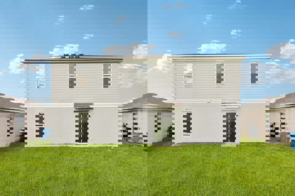 A white house with a green lawn.