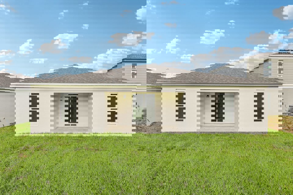 A white house with a green lawn.