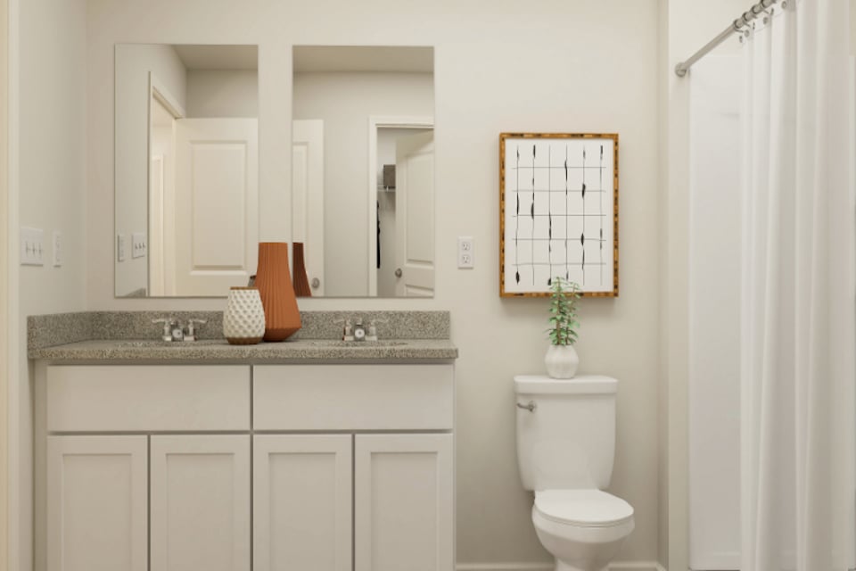 A bathroom with a sink toilet and mirror.