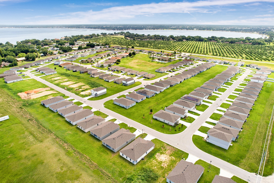 A large green field with buildings.