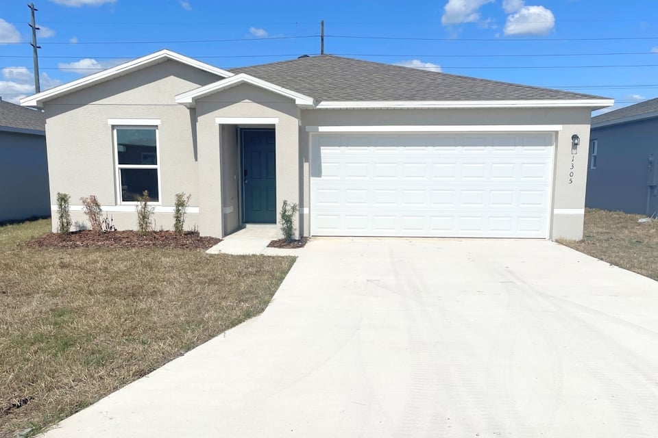 A white house with garages.