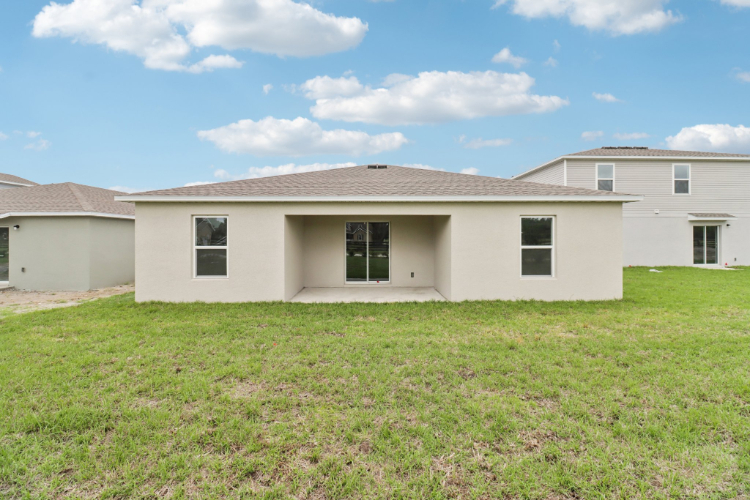 A white house with a grass yard.