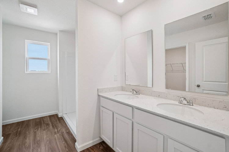 A bathroom with white cabinets.