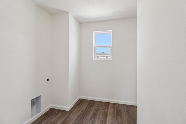 A room with a wood floor and a window.
