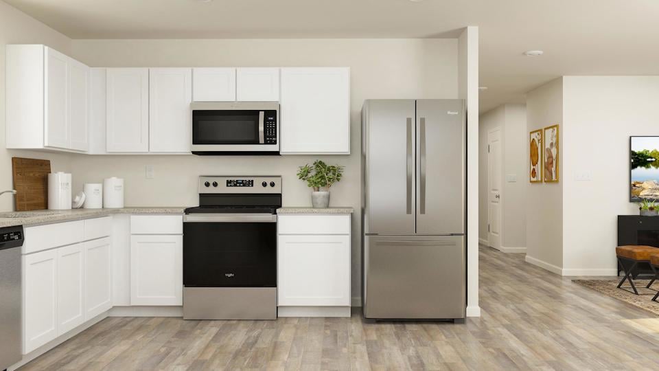 A kitchen with white cabinets.