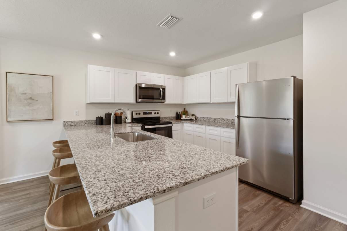 A kitchen with white cabinets.