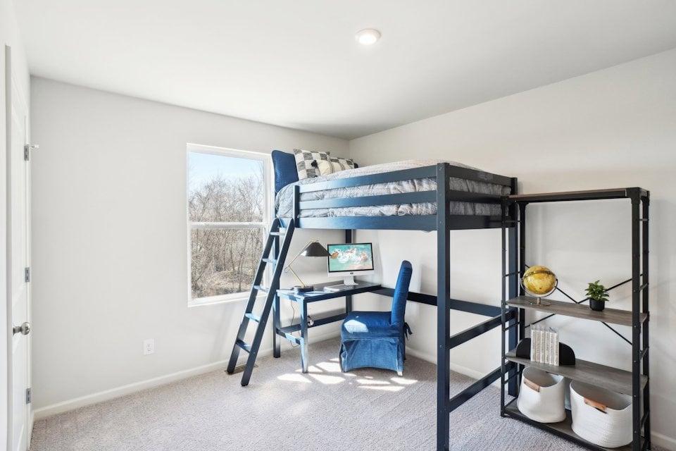 A room with a bunk bed and a chair.