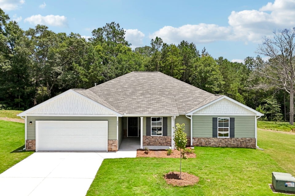 A house with a garage and a grass yard.