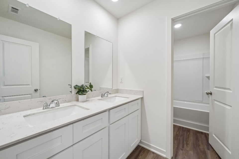 A bathroom with white cabinets.