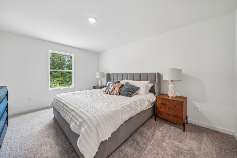 A bedroom with a bed and lamps.
