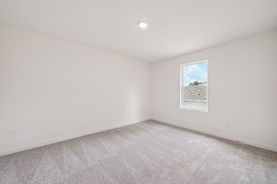 A room with a white wall and a painting on the wall.