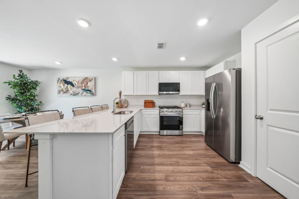 A kitchen with white cabinets.